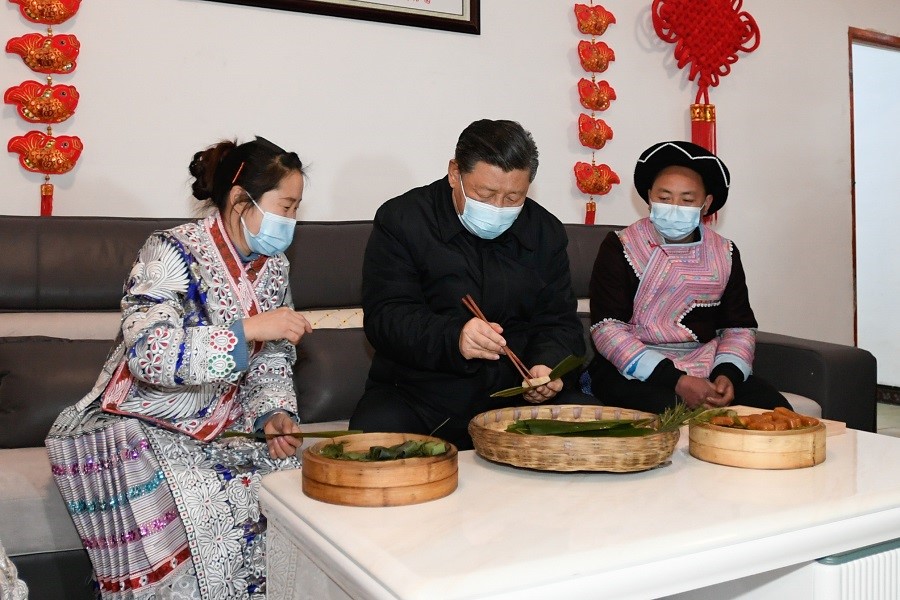 2021年2月3日下午，習(xí)近平在貴州畢節(jié)市黔西縣新仁苗族鄉(xiāng)化屋村苗族村民趙玉學(xué)家，同一家人邊聊家常邊制作當?shù)貍鹘y(tǒng)節(jié)日食品黃粑。新華社記者 李學(xué)仁 攝