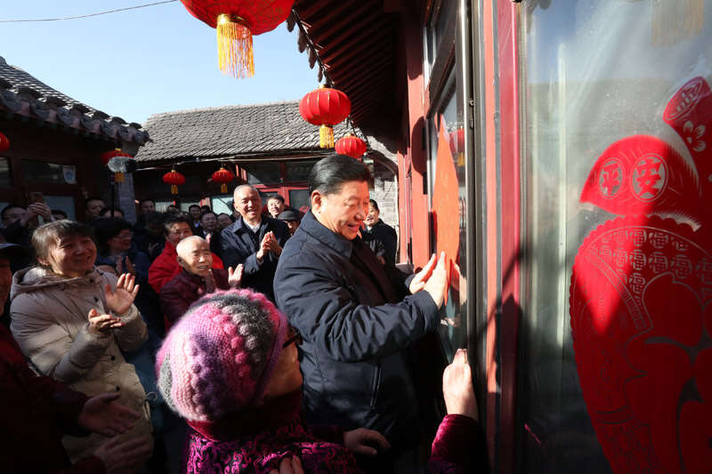 2019年2月1日上午，習(xí)近平在北京前門東區(qū)草廠四條胡同32號院，高興地拿起一幅“福”字，親自貼到門上，給這里的老街坊們拜年。新華社記者 鞠鵬 攝