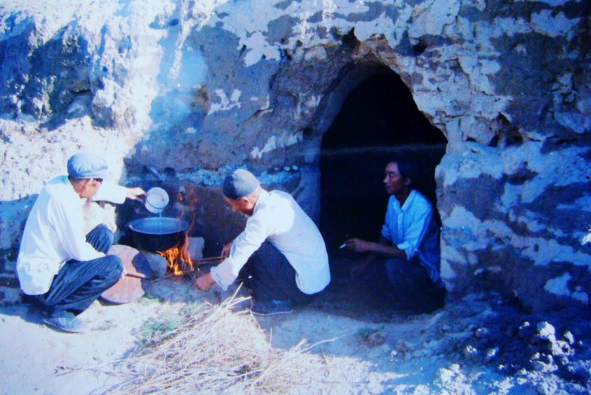 1983年，“六老漢”一代治沙人在“地窩子”生活做飯。新華社發(fā)（八步沙林場供圖）